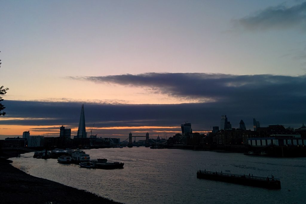 Londresko skylinearen ikuspegia, ilunsentian, ekialdetik ikusita. Tartean The Shard, Tower Bridge, The Walkie Talkie eta The Gherkin ikusten dira, eta uretan ontziak.